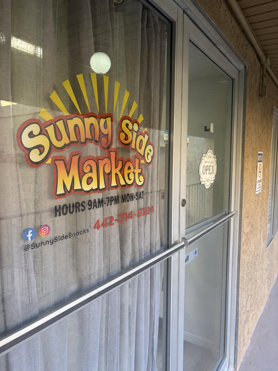 Sunny Side Market sign on the window beside its entrance door